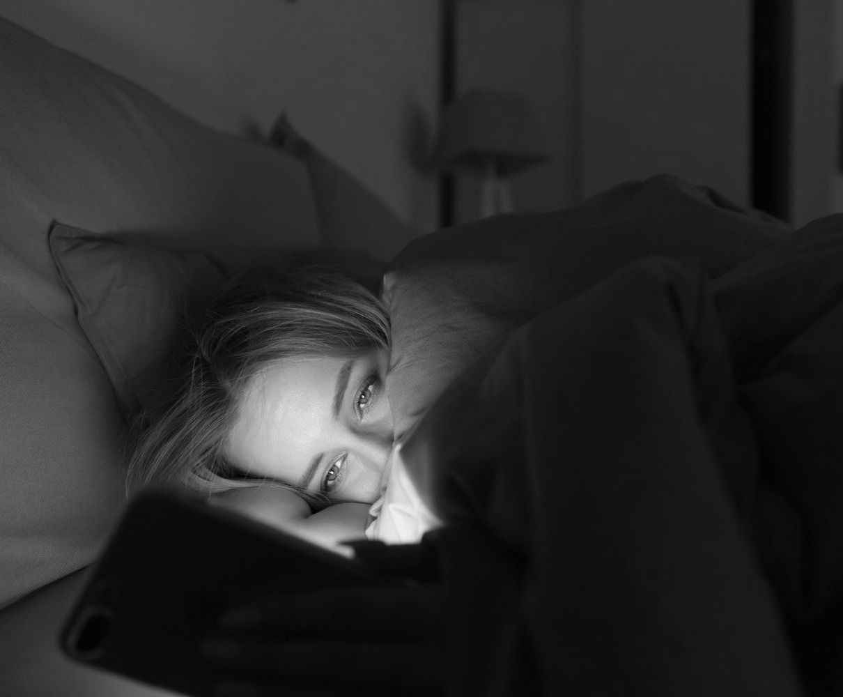 sad girl in bed texting at night