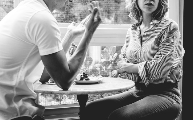 a troubled couple sitting at a cafe after fighting