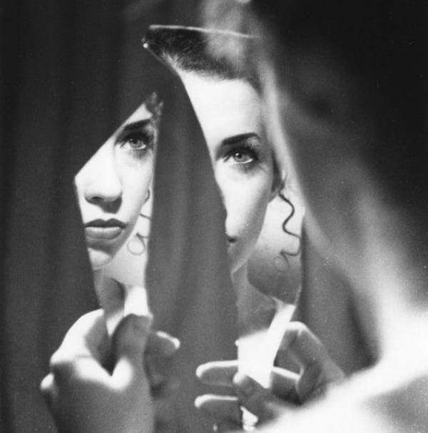 woman looking at her reflection in a mirror