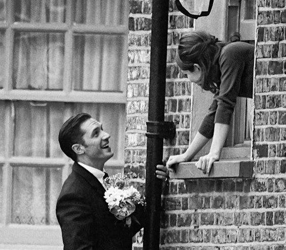 guy giving girl flowers through window